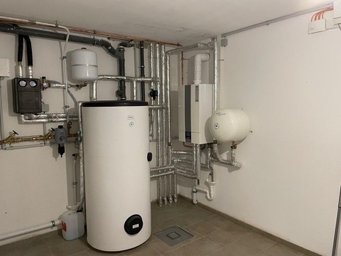 Technikraum mit Warmwasserspeicher und Heizungsverteilung