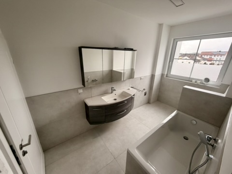 Familienbad mit Badewanne und dunklem Waschtischunterschrank