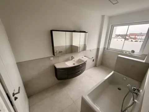 Familienbad mit Badewanne und dunklem Waschtischunterschrank